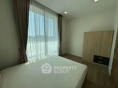 Bright bedroom with large window and modern wardrobe, perfect for serene living.