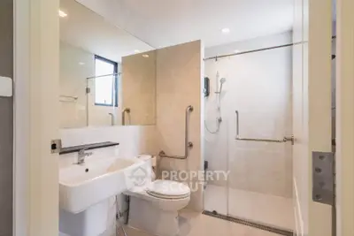 Modern bathroom with glass shower and sleek fixtures in a contemporary home.