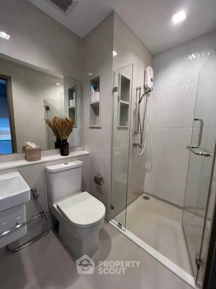 Modern bathroom with glass shower and sleek fixtures in a contemporary home.