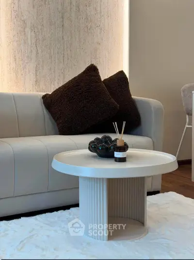 Stylish modern living room with plush sofa and chic round coffee table on a cozy rug.
