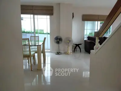 Spacious open-plan living and dining area with modern furniture and large windows.