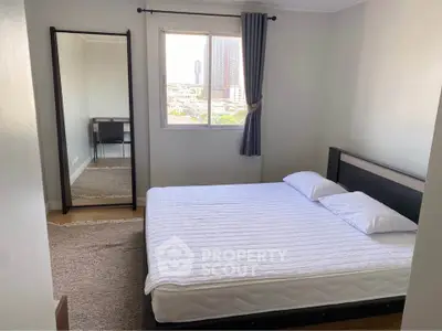 Cozy bedroom with city view, featuring a comfortable bed and stylish decor, perfect for relaxation.