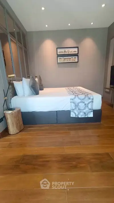 Luxurious bedroom with elegant decor and wooden flooring in a modern apartment.