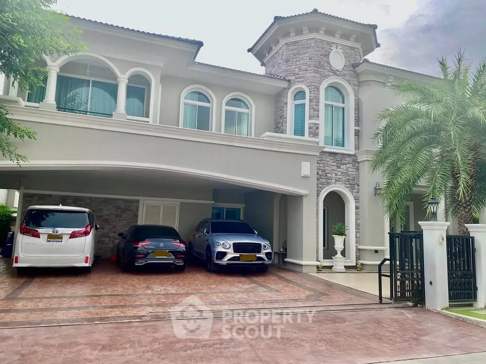 Luxurious two-story home with elegant stone facade and spacious driveway for multiple cars.