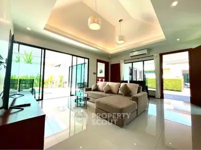 Spacious modern living room with large windows and elegant lighting in a luxury home.