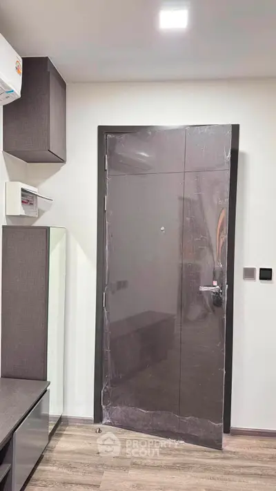 Modern interior with sleek door and stylish cabinetry in a contemporary apartment.