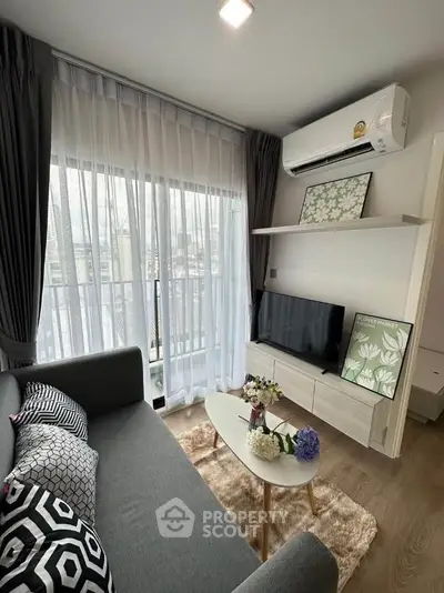 Modern living room with stylish decor, large window, and cozy seating area.