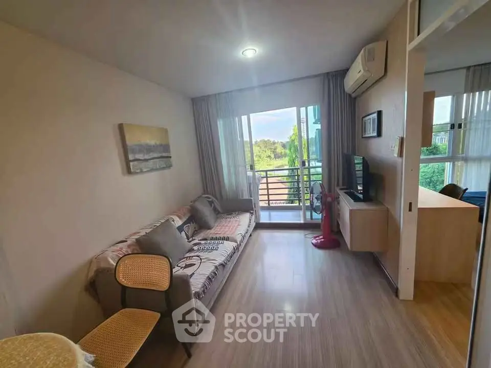 Cozy living room with balcony view, modern decor, and natural light in a stylish apartment.