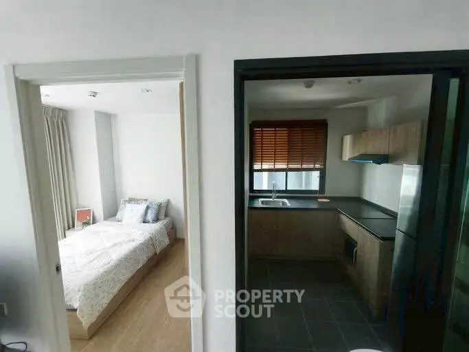 Modern apartment interior with cozy bedroom and sleek kitchen design.