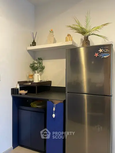 Modern kitchen corner with stainless steel fridge and stylish shelving