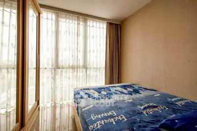 Bright bedroom with large windows and cozy bedding in modern apartment.