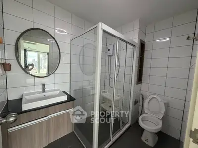 Modern bathroom with glass shower and sleek vanity in urban apartment