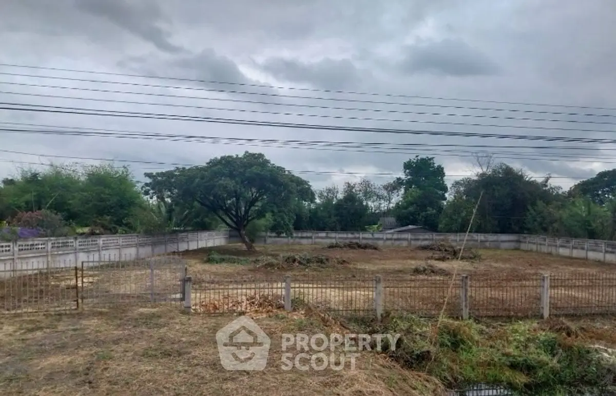 Spacious vacant land with potential for development, surrounded by lush greenery and a serene environment.