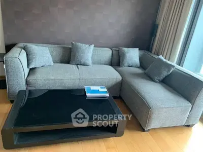 Modern living room with stylish gray sectional sofa and sleek black coffee table.