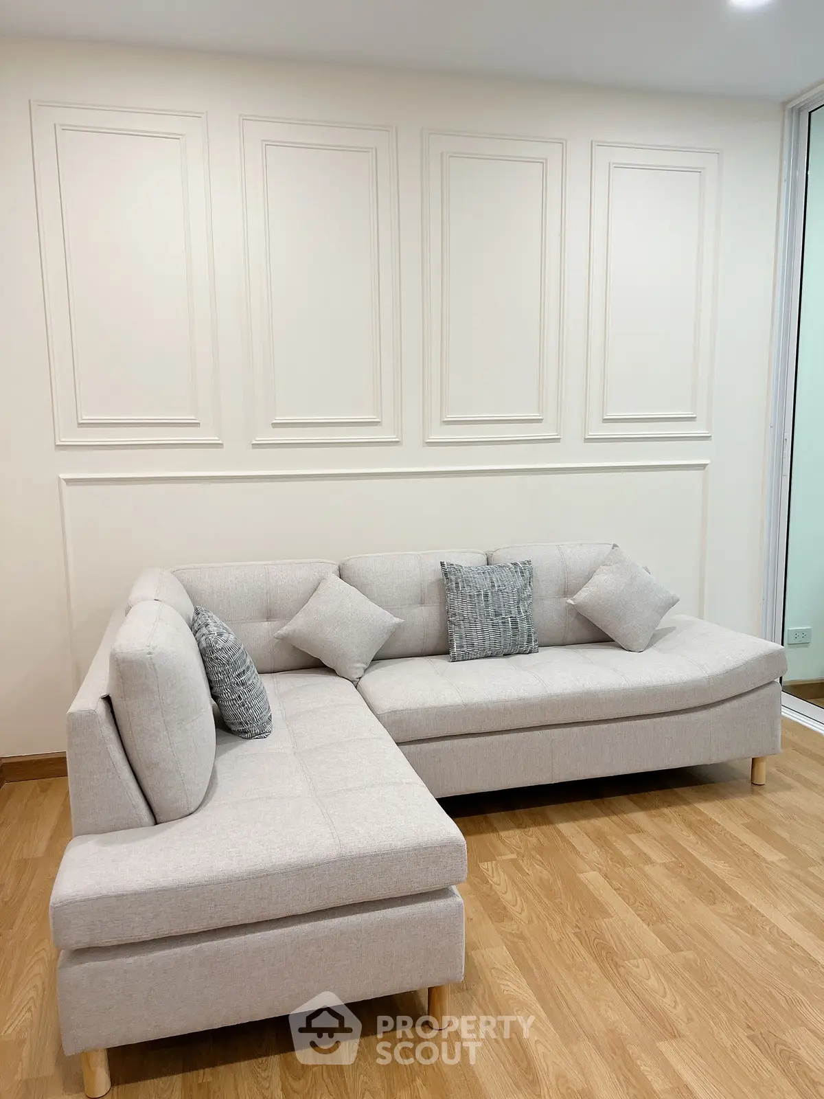 Elegant living room with modern L-shaped sofa and stylish wall paneling