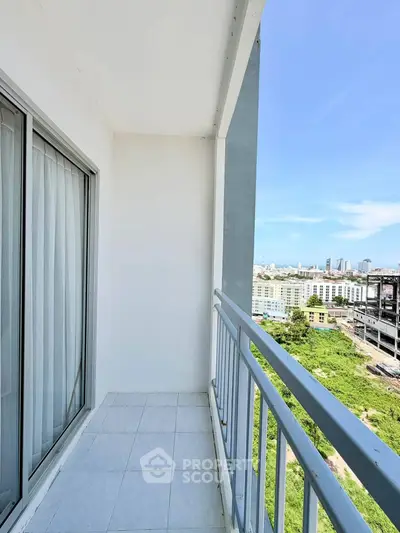 Spacious balcony with stunning cityscape views in modern high-rise apartment.