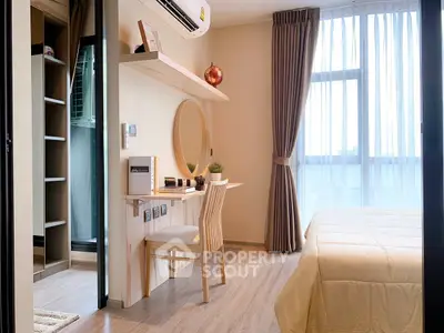 Modern bedroom with stylish decor, large window, and cozy workspace, perfect for urban living.