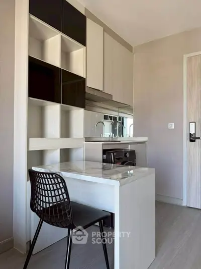 Modern compact kitchen with sleek cabinetry and integrated appliances in a stylish apartment.