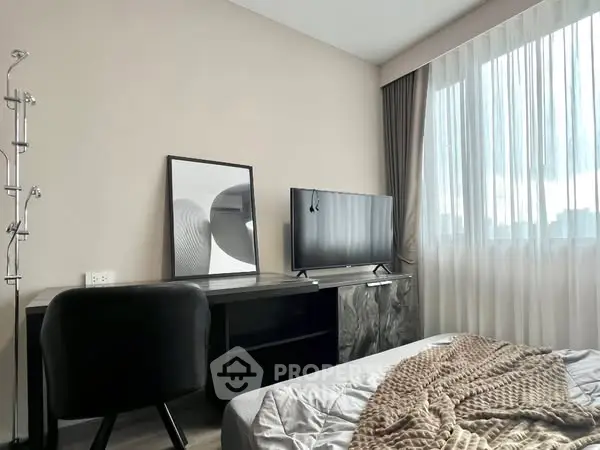 Modern bedroom with sleek furniture and large window for natural light.