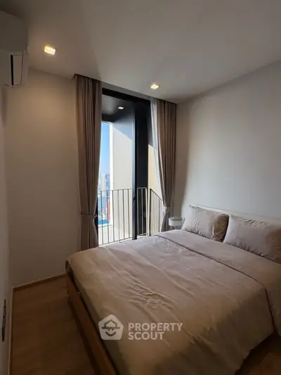 Modern bedroom with balcony view in a high-rise apartment, featuring sleek design and natural light.