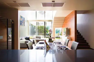 Luxurious open-plan living room with modern dining area and stunning natural light.