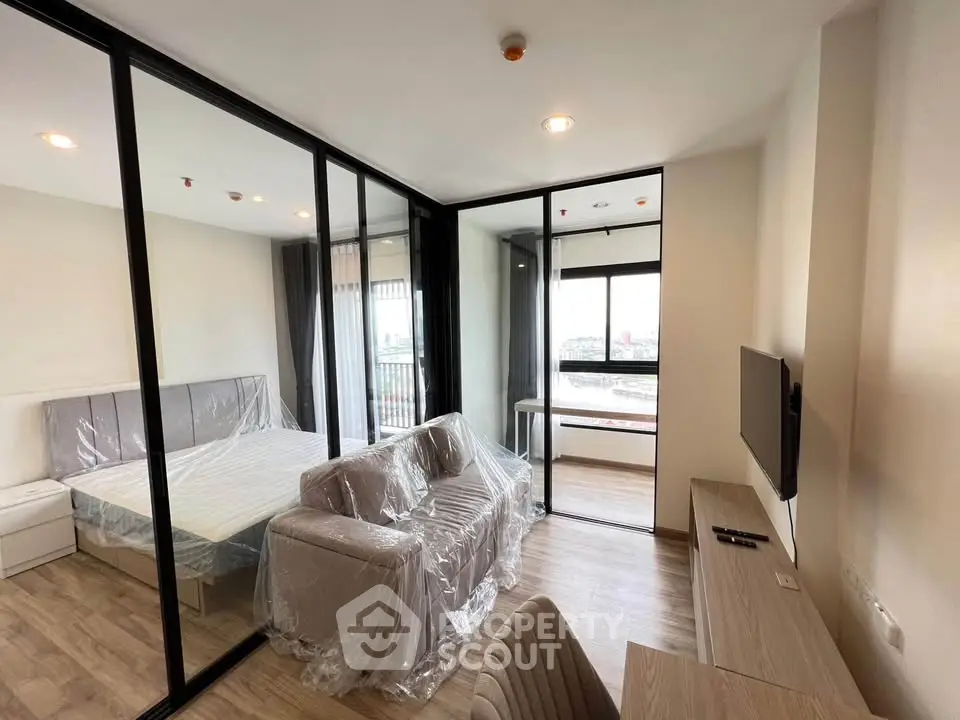 Modern apartment with glass partitioned bedroom and cozy living area