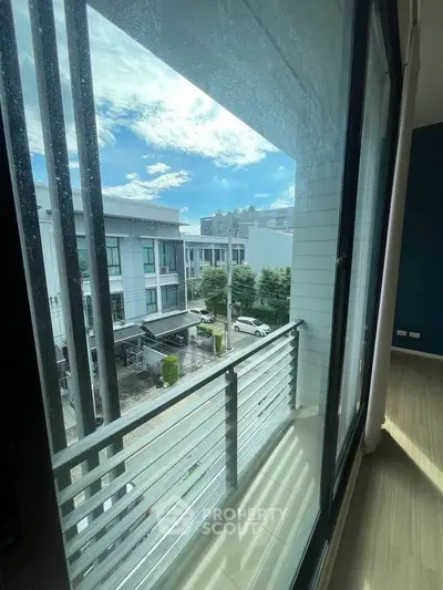 Modern balcony view with sleek railing and urban neighborhood scenery.
