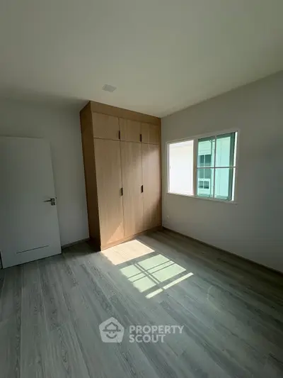 Spacious bedroom with natural light and built-in wardrobe