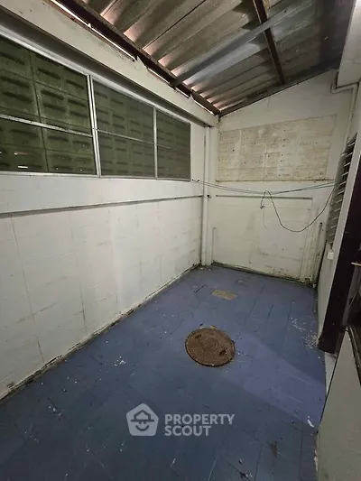 Spacious storage area with blue tiled floor and metal roof, ideal for versatile use.