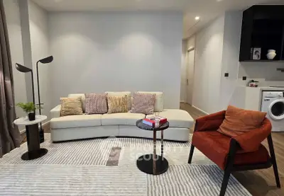 Modern living room with stylish furniture and washing machine in corner