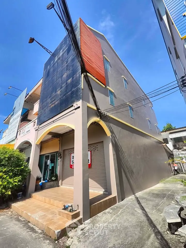 Modern multi-story building with unique facade design and spacious entrance.