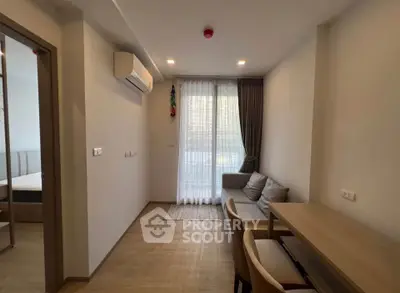 Modern living room with natural light, air conditioning, and cozy seating area in a stylish apartment.