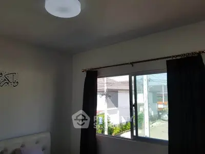 Cozy bedroom with window view and dark curtains, perfect for relaxation.