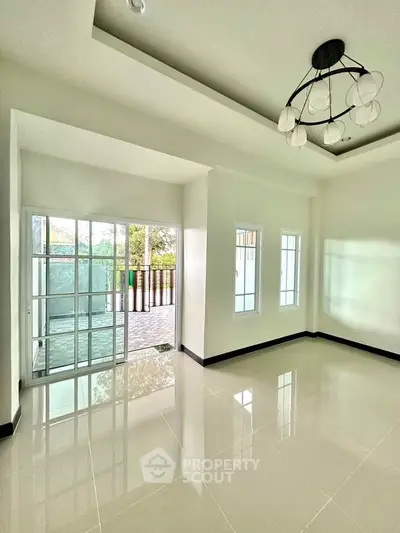 Bright and spacious living room with modern chandelier and large windows