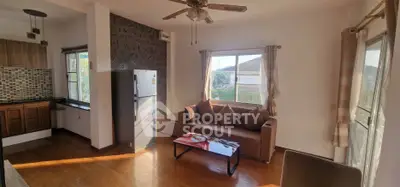 Cozy living room with natural light and modern kitchen in open layout apartment.