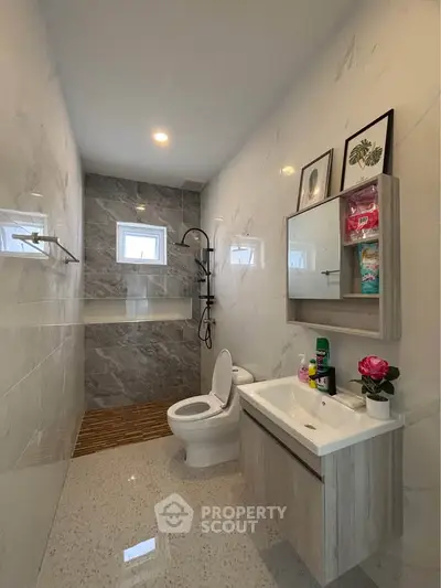 Modern bathroom with sleek design, featuring a shower, toilet, and stylish vanity unit.