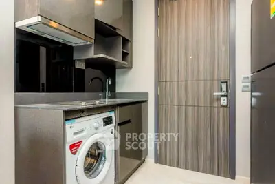 Modern compact kitchen with washing machine and sleek cabinetry