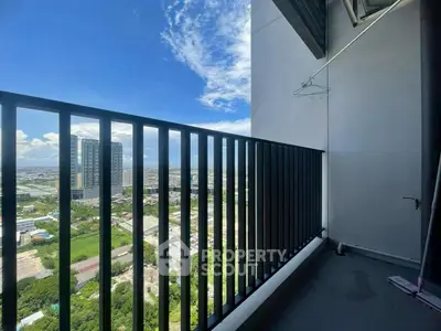 Stunning high-rise balcony with panoramic city views and clear blue skies.