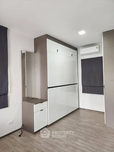 Modern bedroom with sleek built-in wardrobe and air conditioning