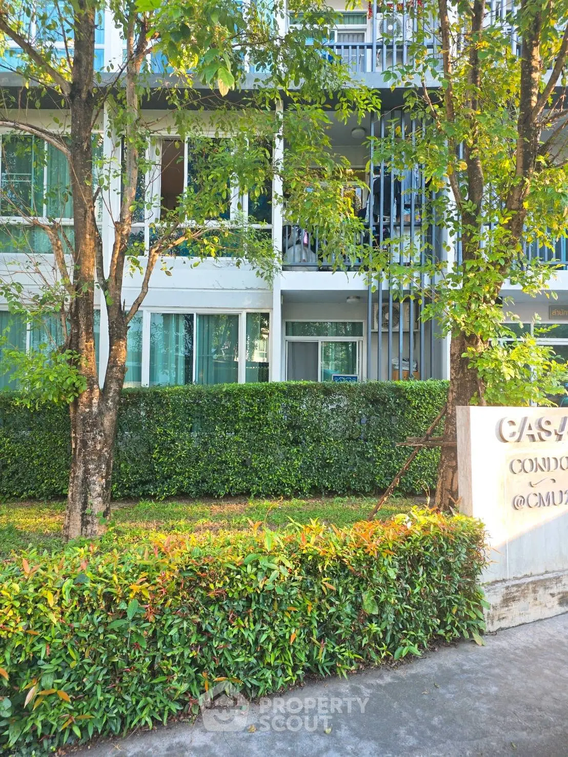 Modern condo exterior with lush greenery and stylish facade