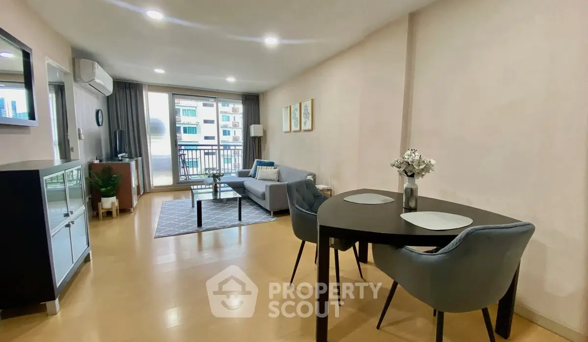 Modern living room with dining area and balcony view in a stylish apartment.