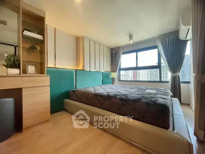 Modern bedroom with large window and city view, featuring stylish decor and ample natural light.