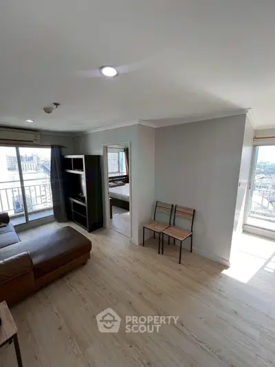 Spacious living room with modern decor and large windows offering city views.