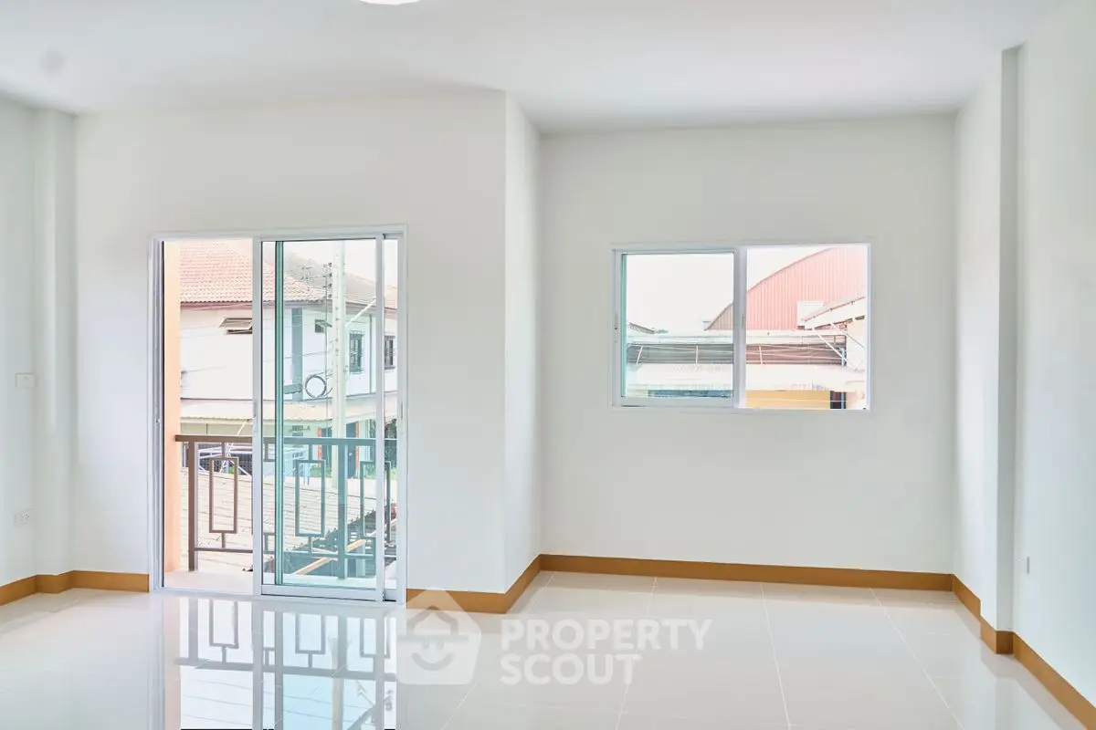 Bright and spacious room with large windows and balcony access, perfect for modern living.