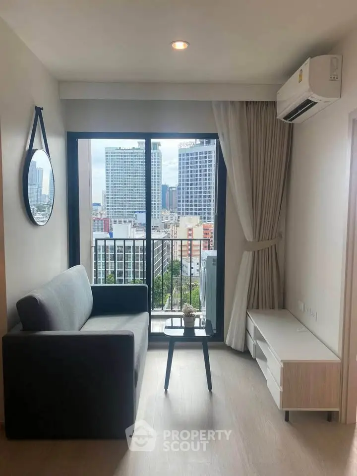Modern living room with city view, stylish sofa, and air conditioning in high-rise apartment.