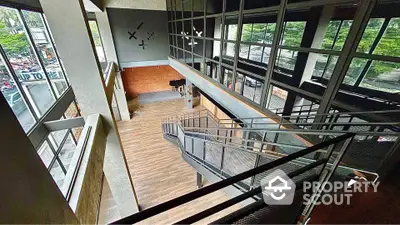 Spacious modern industrial loft with large windows and mezzanine level.