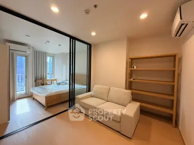 Modern apartment interior with cozy living room and bedroom, featuring a sleek glass partition and natural light.