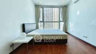 Spacious bedroom with large window offering city views, featuring a modern bed and sleek wooden flooring.