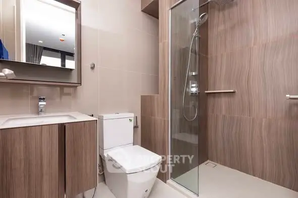 Modern bathroom with sleek wooden cabinetry and glass shower enclosure
