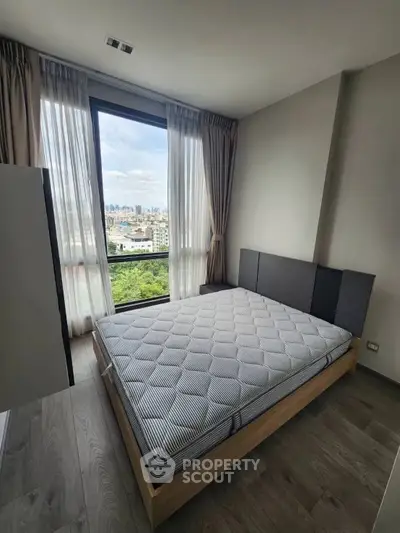 Modern bedroom with large window offering stunning city view